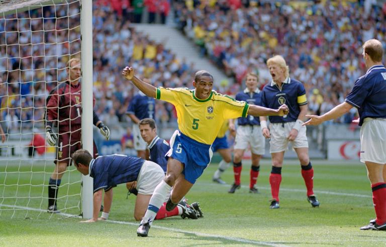 PARIS, FRANCE - JUNE 10: Cesar Sampaio of Brazil celebrates scoring the opening goal of the World Cup as Scotland captain Colin Hendry (2nd r) reacts  during the group A game against Scotland at the Stade de France in St Denis, France,  Brazil won 2-1.  (Photo Shaun Botterill/Allsport/Getty Images)