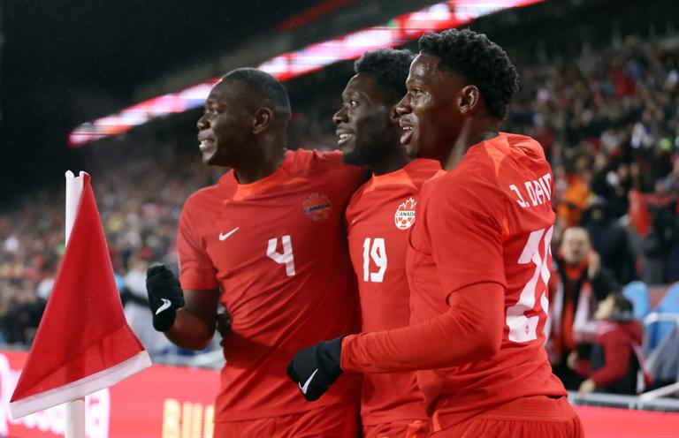TORONTO, ON - NOVEMBER 21:  Alphonso Davies #19 (C) of Canada celebrates a goal with Kamal Miller #4 and Jonathan David #20 during a CONCACAF Nations League match against Jamaica at BMO Field on November 21, 2023 in Toronto, Ontario, Canada.  (Photo by Vaughn Ridley/Getty Images)