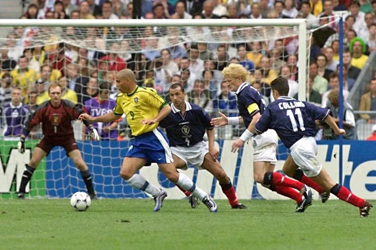 Brasilian forward Ronaldo tries to dribble past Scottish Colin Calderwood, Colin Hendry and John Collins, 10 June at the Stade de France in Saint-Denis, as goalie Jim Leighton looks on during their World Cup Group A opening match. The defending champions beat Scotland 2-1. (IMAGE ELECTRONIQUE) (Photo by THOMAS COEX / AFP) (Photo by THOMAS COEX/AFP via Getty Images)          